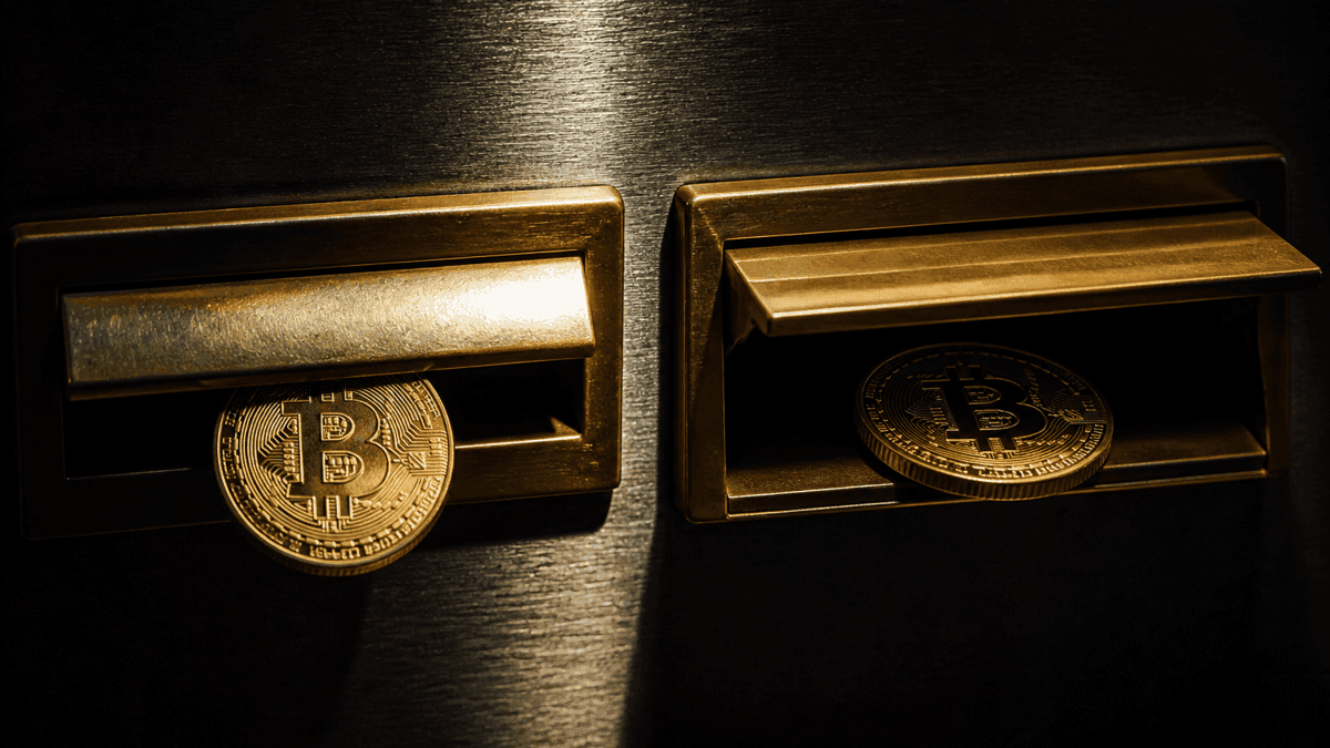 Zwei fast identische messingfarbene Briefkastenklappen nebeneinander in einer dunklen Metallwand; in den linken Schlitz kippt eine Münze mit Bitcoin-Symbol ins Dunkle, hinter der rechten Klappe liegt eine gleiche Münze sicher im Fach
