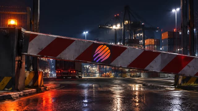 Sich senkende Stahlschranke vor einem nächtlichen Frachtterminal, in das Metall der Schranke ist das Meteora-Zeichen als glühende Intarsie eingelassen