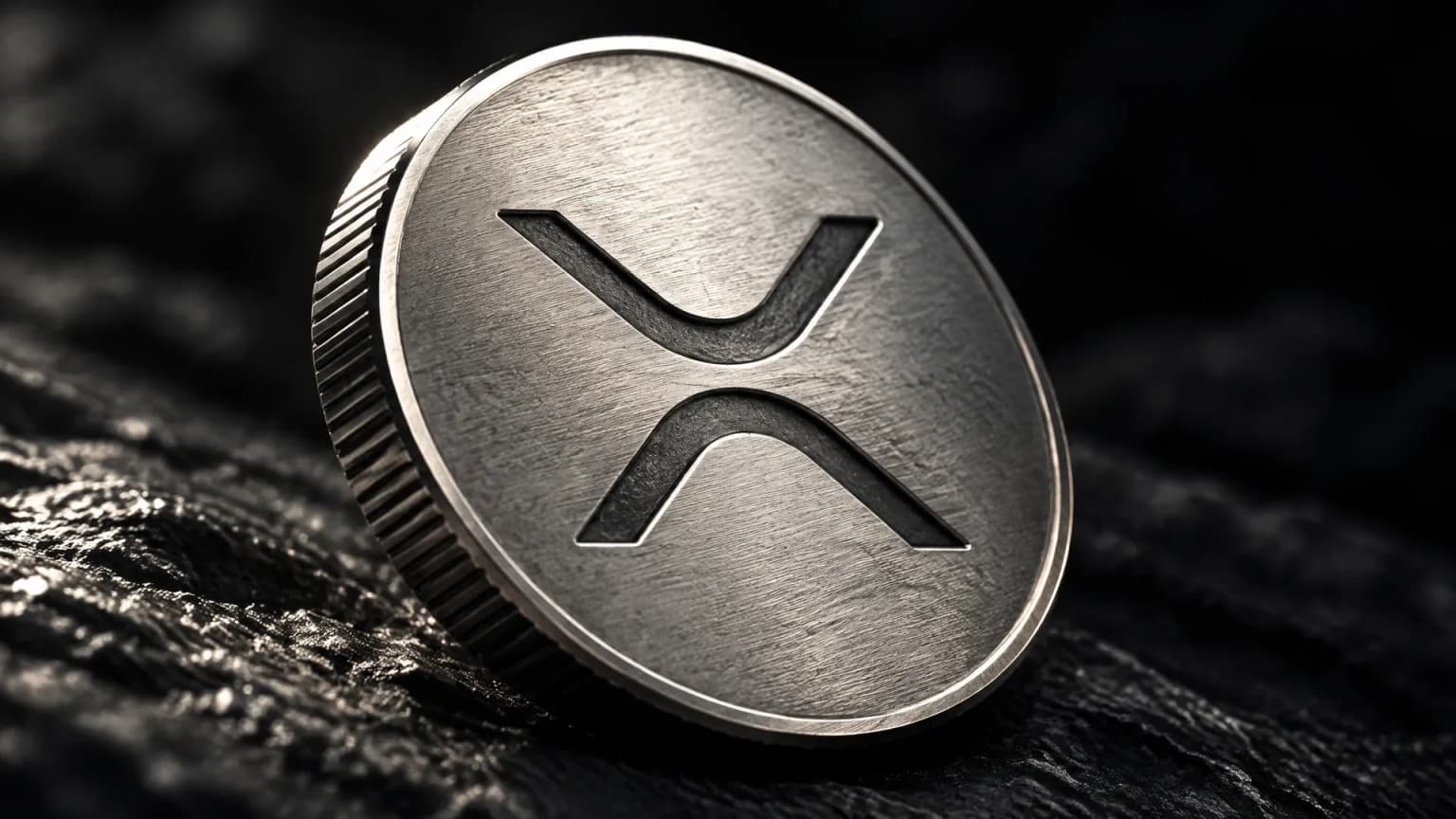 Pièce d'argent frappée du symbole XRP sur une ardoise sombre