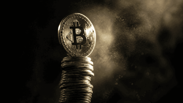 Hochglanzpolierte Metallmünze mit eingeprägtem Bitcoin-Zeichen balanciert auf der Spitze eines steil aufragenden Münzturms