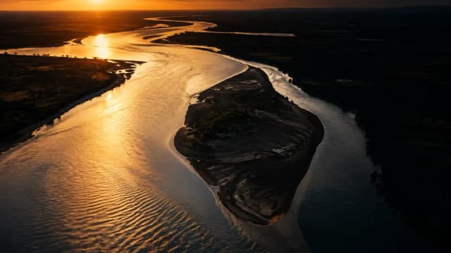 Flussmündung aus der Luft in der Dämmerung, das Wasser teilt sich in zwei Arme