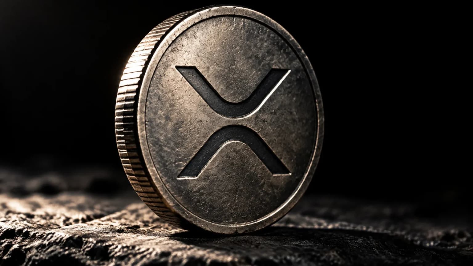 Schwere gepraegte Metallmuenze mit dem XRP-Zeichen aufrecht auf einer Steinplatte im harten Seitenlicht